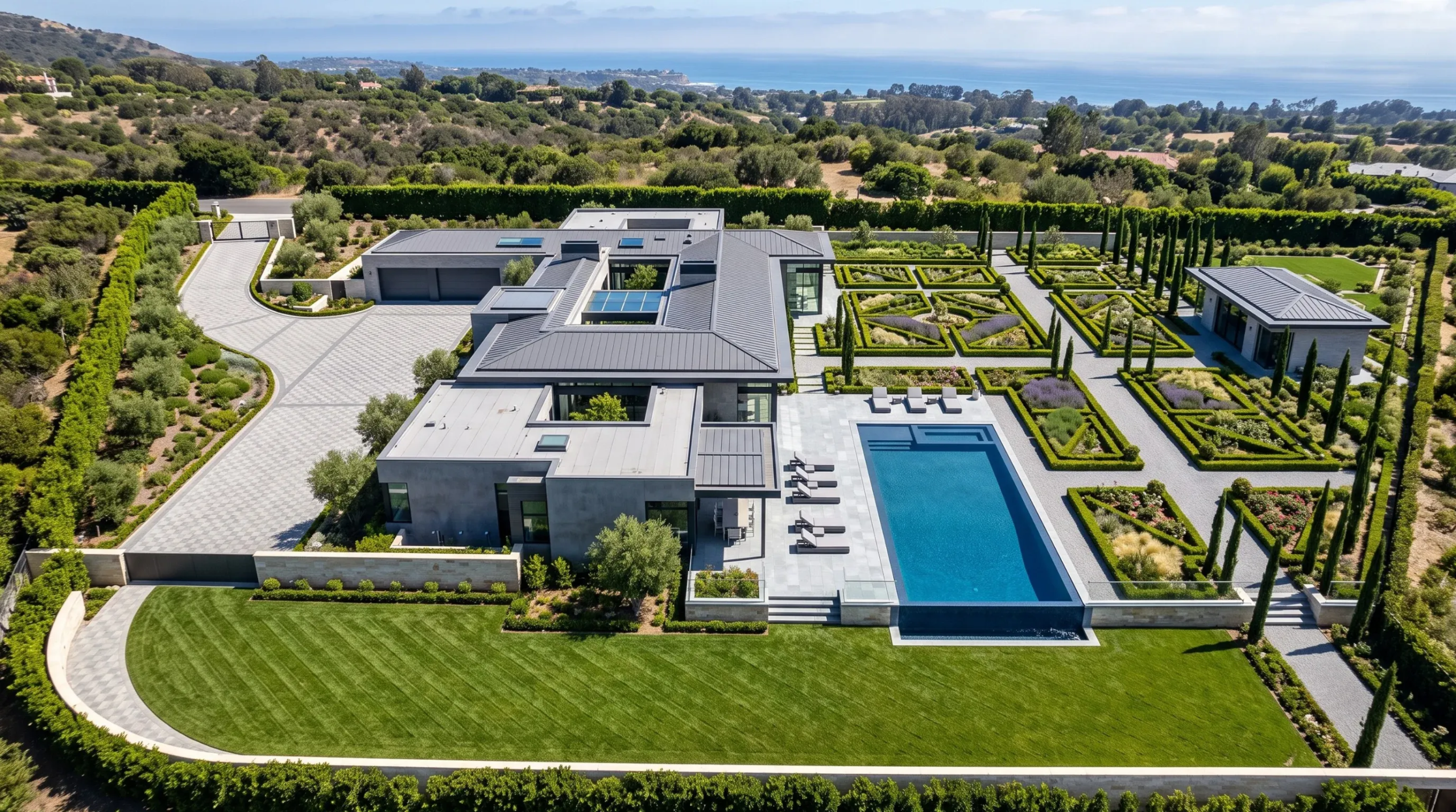 Vista aérea de una residencia de lujo moderna con piscina, jardines formales y vista al mar, diseño exclusivo de RBA Residences en Zapopan.