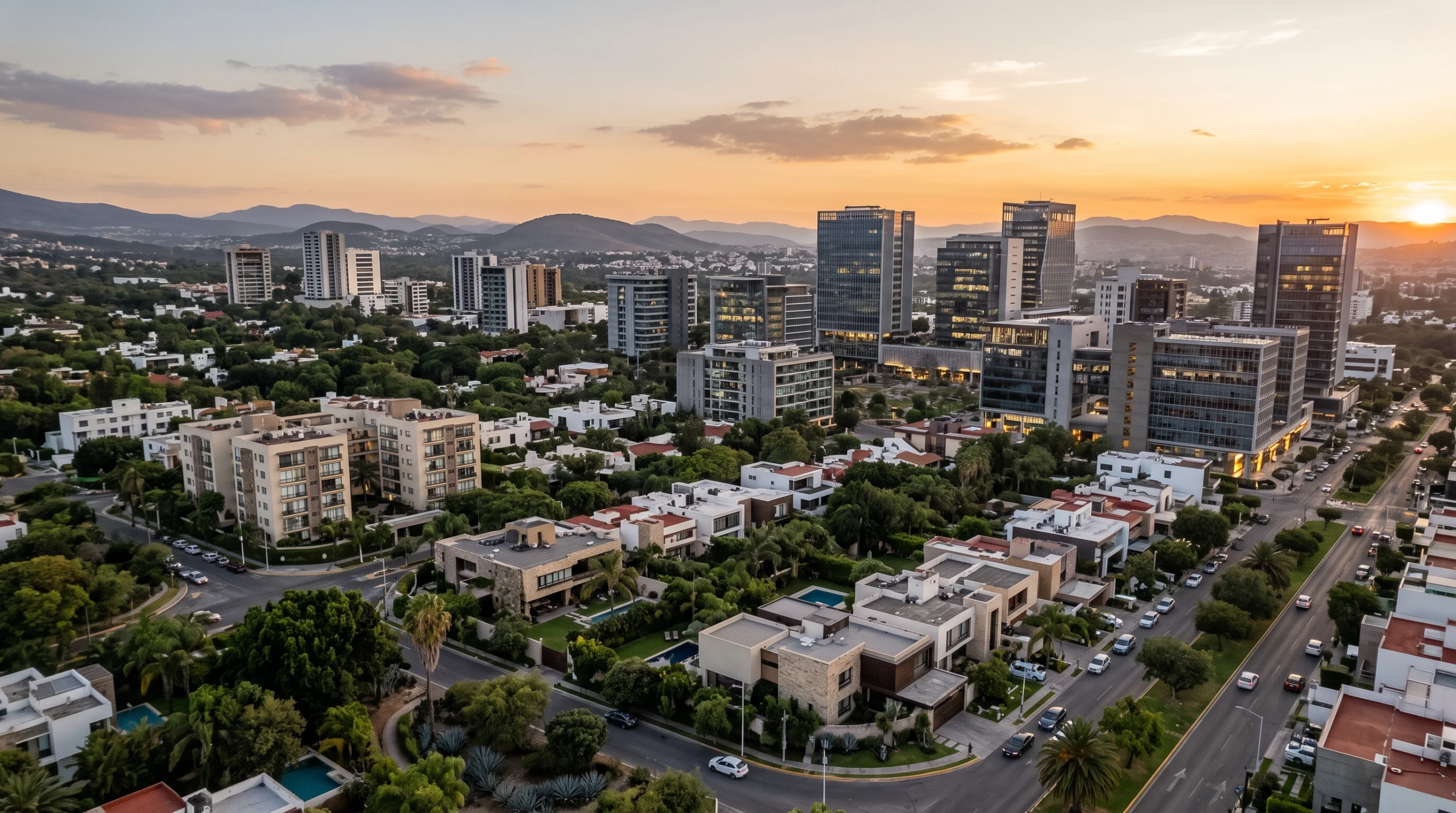 Vista aérea panorámica al atardecer de vecindarios residenciales de lujo de baja densidad con albercas privadas en primer plano, que transicionan hacia arquitectura comercial de mediana y gran altura enmarcada por contornos montañosos distantes, representando la ubicación estratégica y la conexión urbano-natural de RBA Residences en Zapopan.
